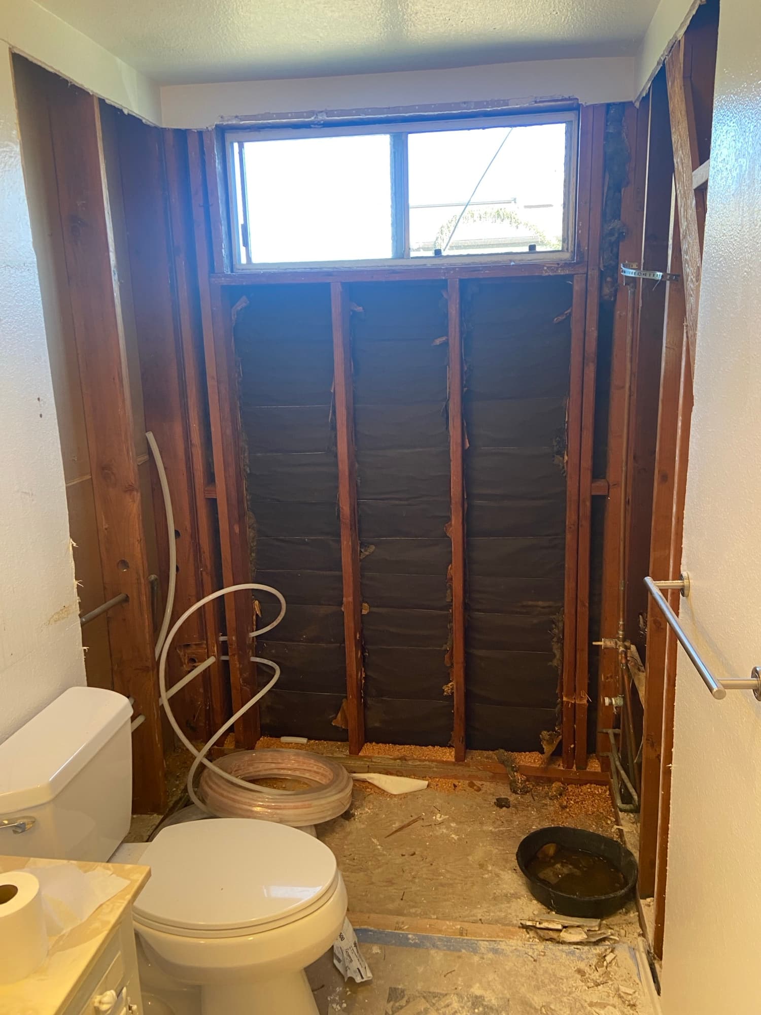 Black ABS drain pipes and PEX lines routed through floor joists, Orange County, CA