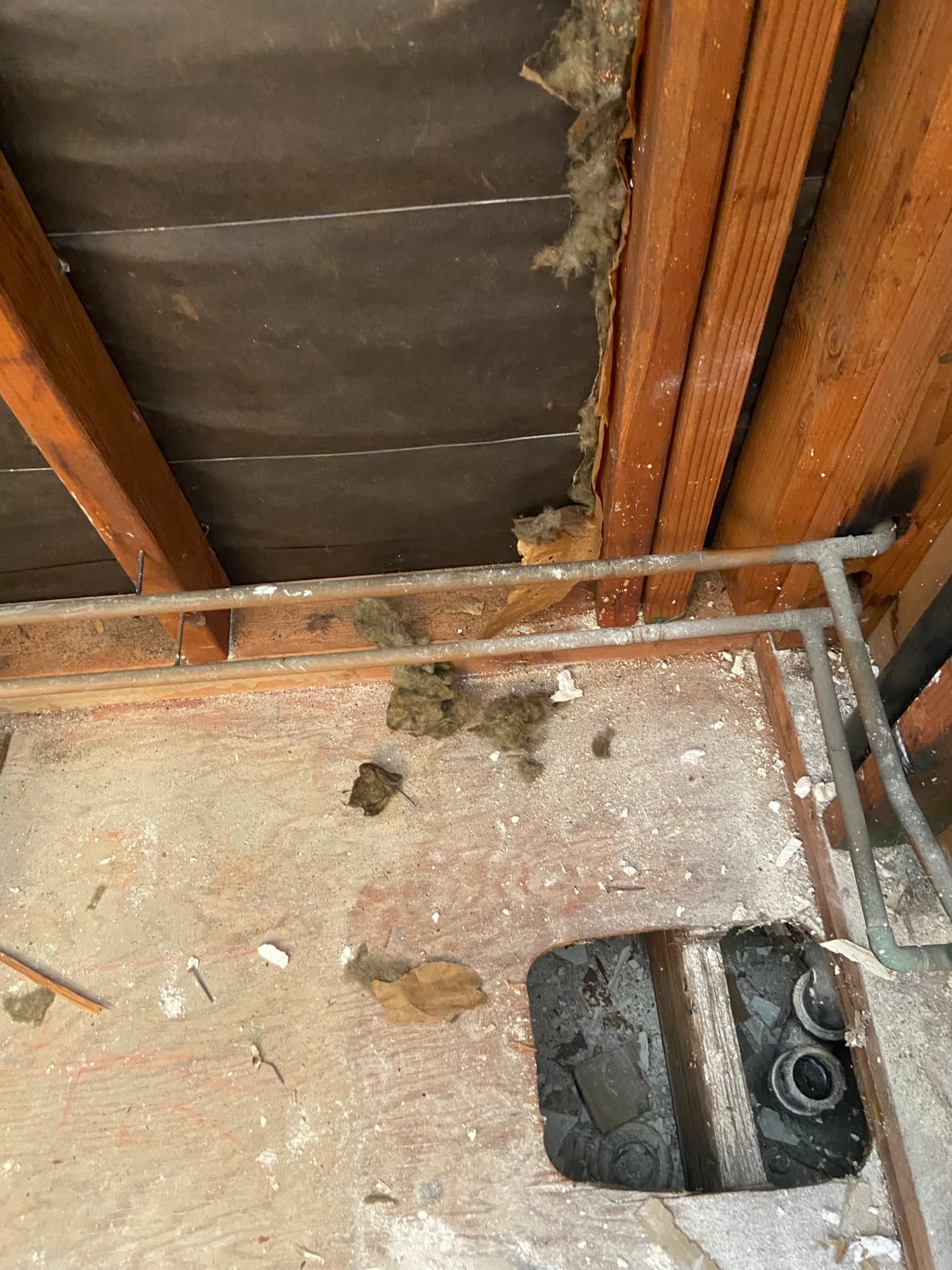 Access hole cut into drywall exposing a hose-clamped cast iron pipe coupling, Orange County, CA