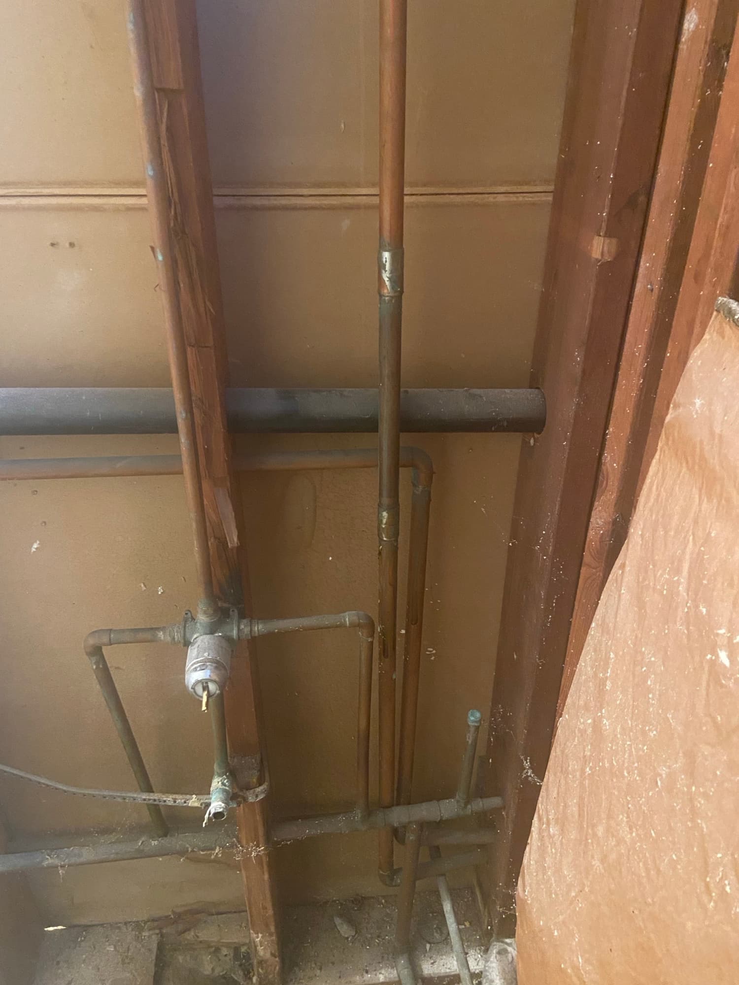 Copper pipe elbow and brass shutoff valve fitting installed beneath an Orange County home