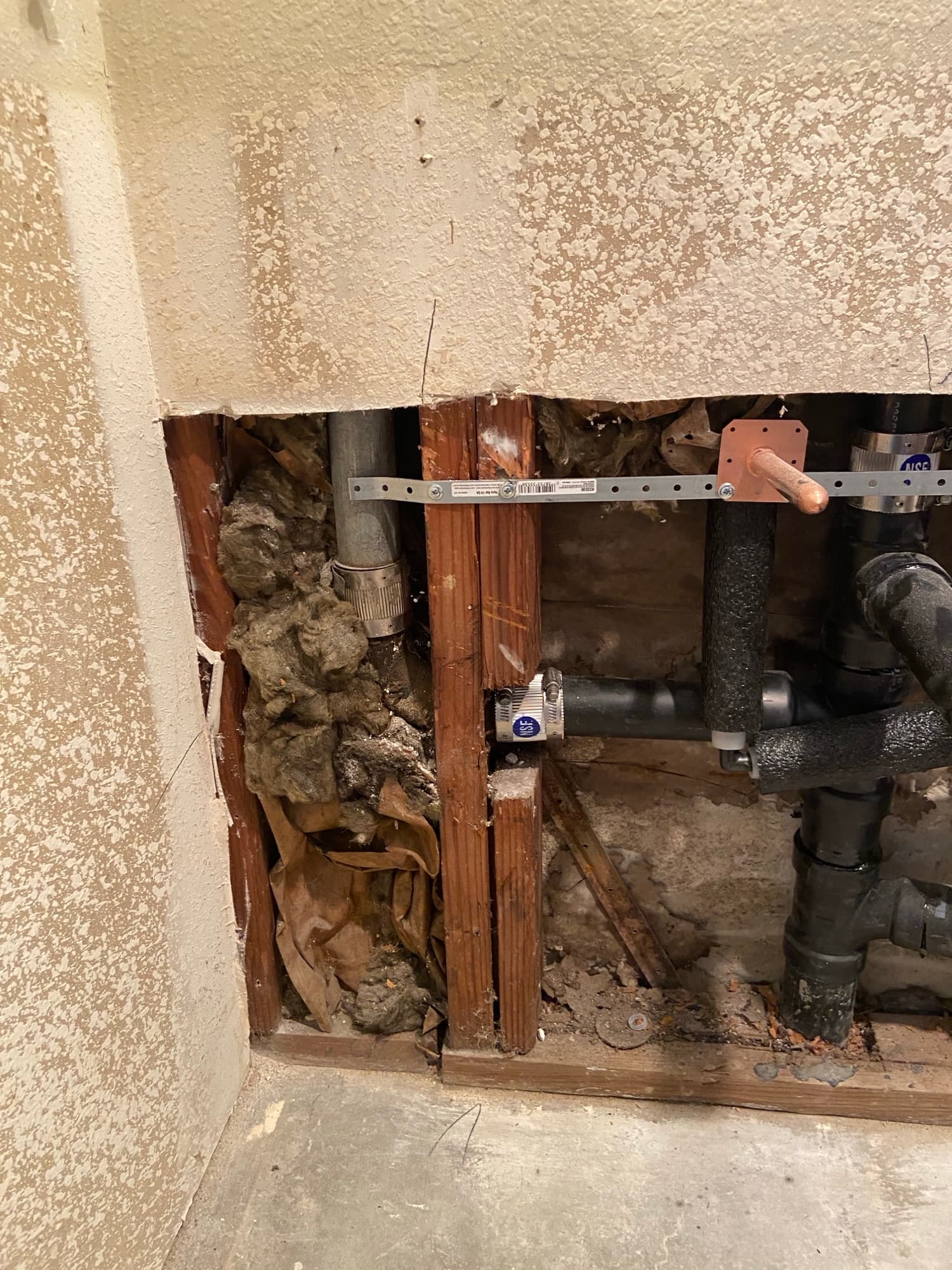 Exposed wall cavity with copper stub-out and ABS drain pipe during a repipe, Orange County, CA
