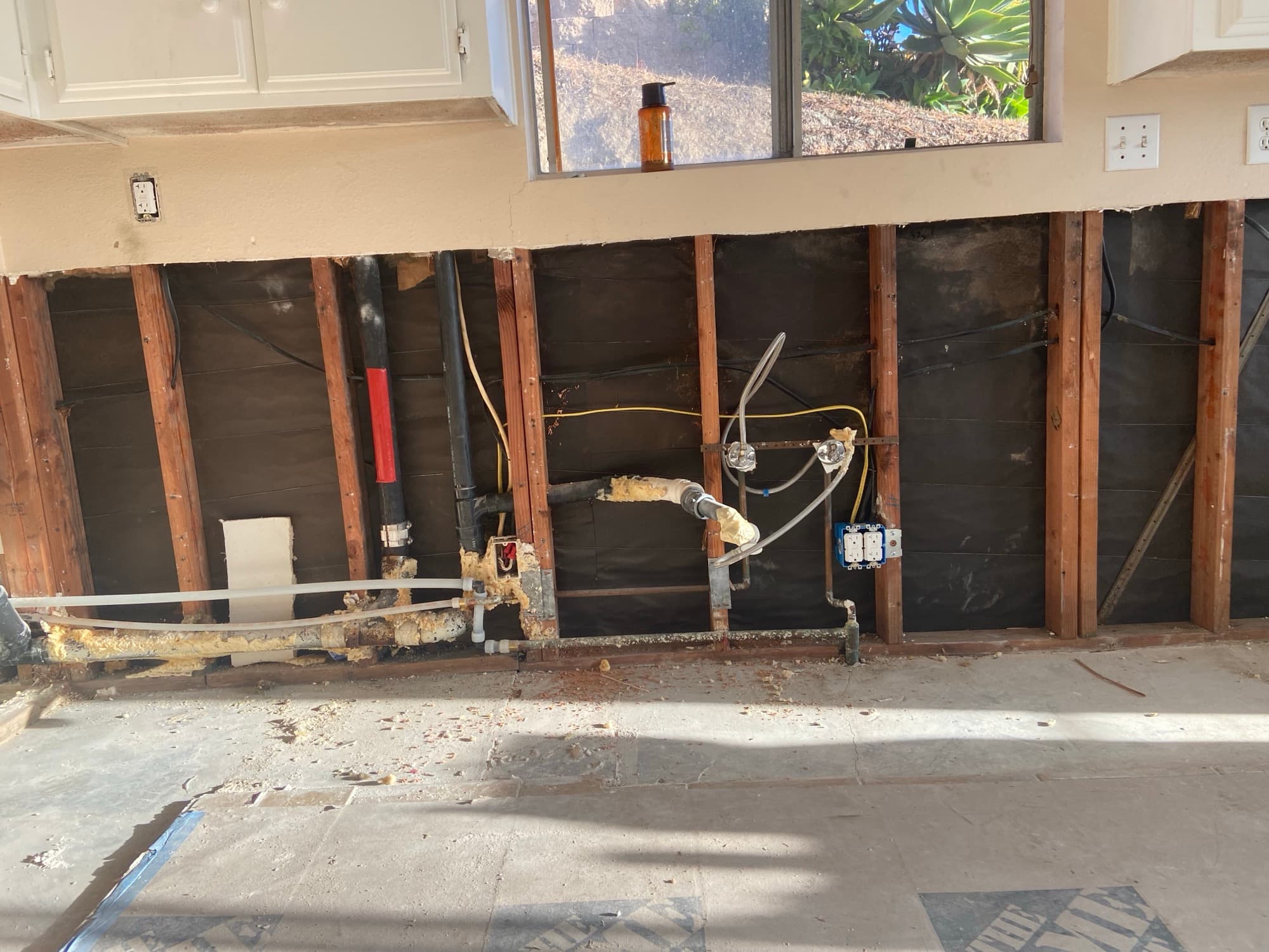 Rough plumbing exposed in an open wall with copper stub-outs and PEX tubing, Orange County, CA