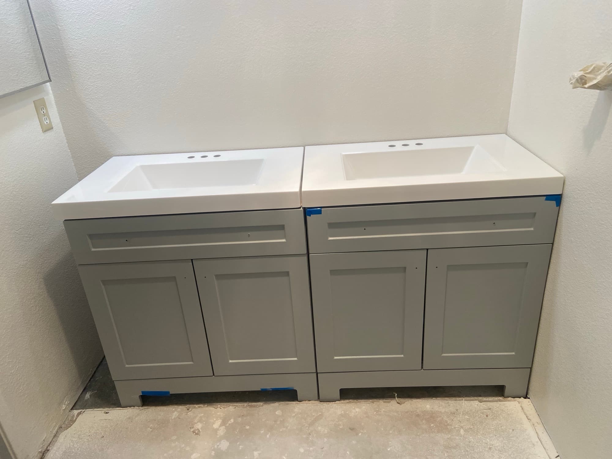 Two matching gray bathroom vanities with white sink tops freshly installed, Orange County, CA