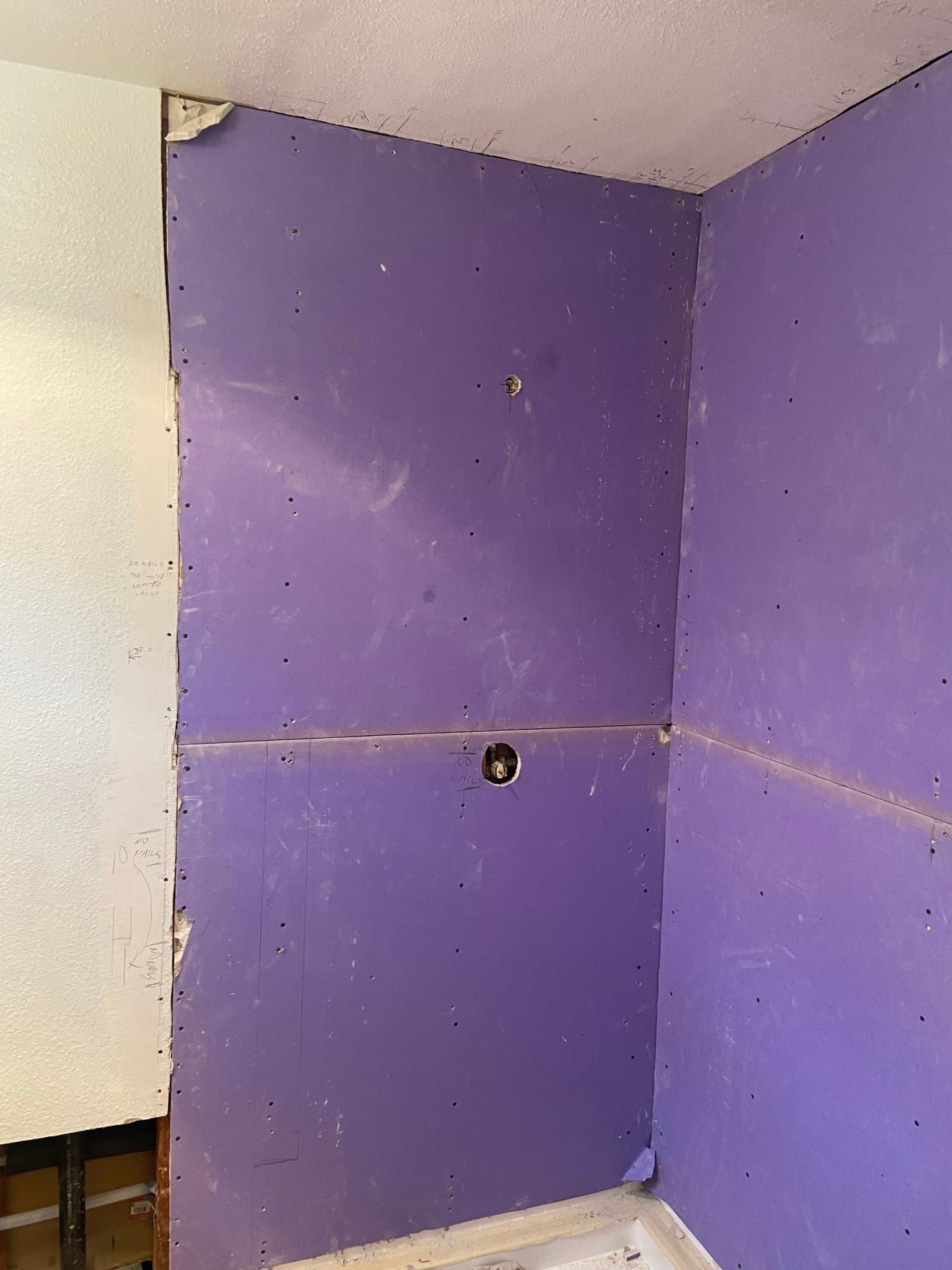 Newly installed moisture-resistant drywall in a shower corner, ready for tile, Orange County, CA