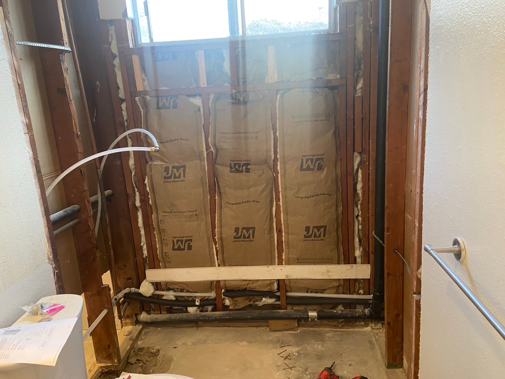 Shower alcove stripped to the studs with insulation and a water line rough-in, Orange County, CA