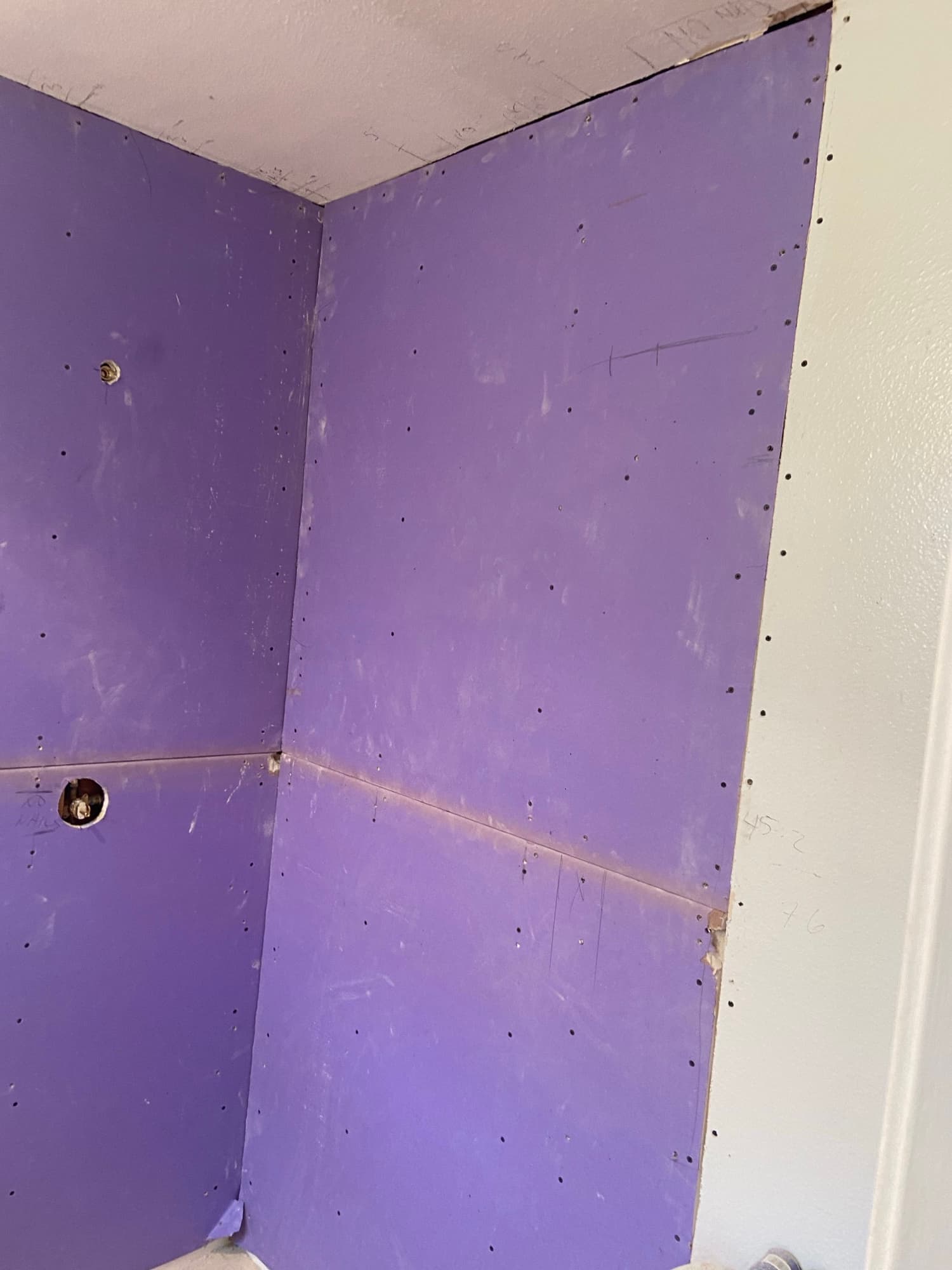 Purple moisture-resistant board seams and patched access holes in a shower wall, Orange County, CA