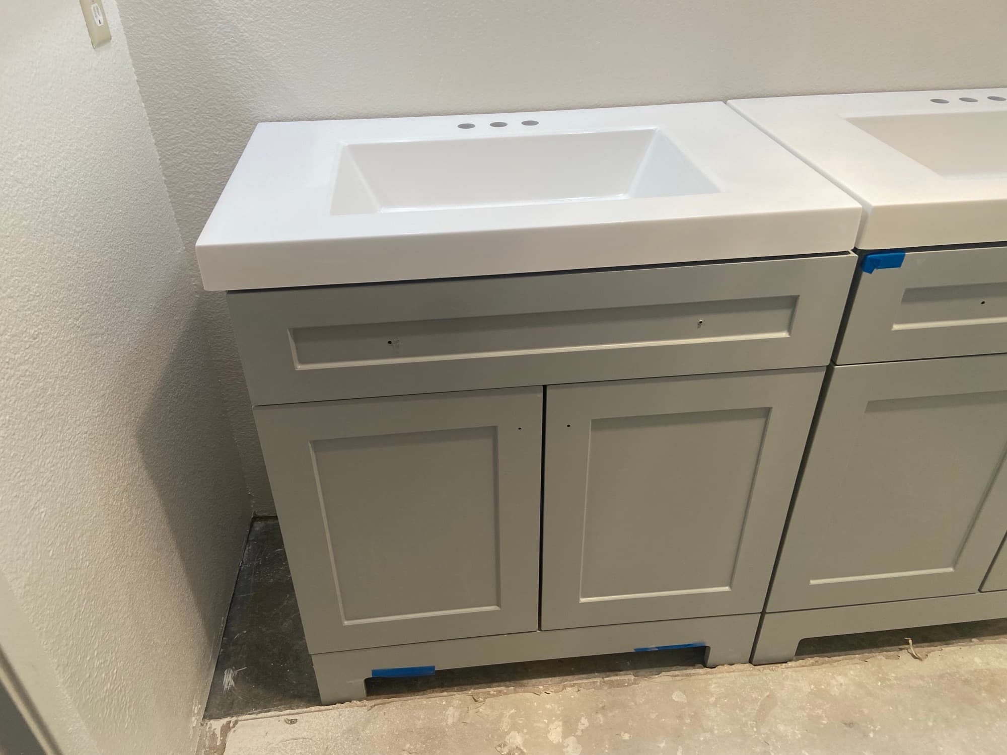 Single gray vanity cabinet with a new white sink top installed, Orange County, CA