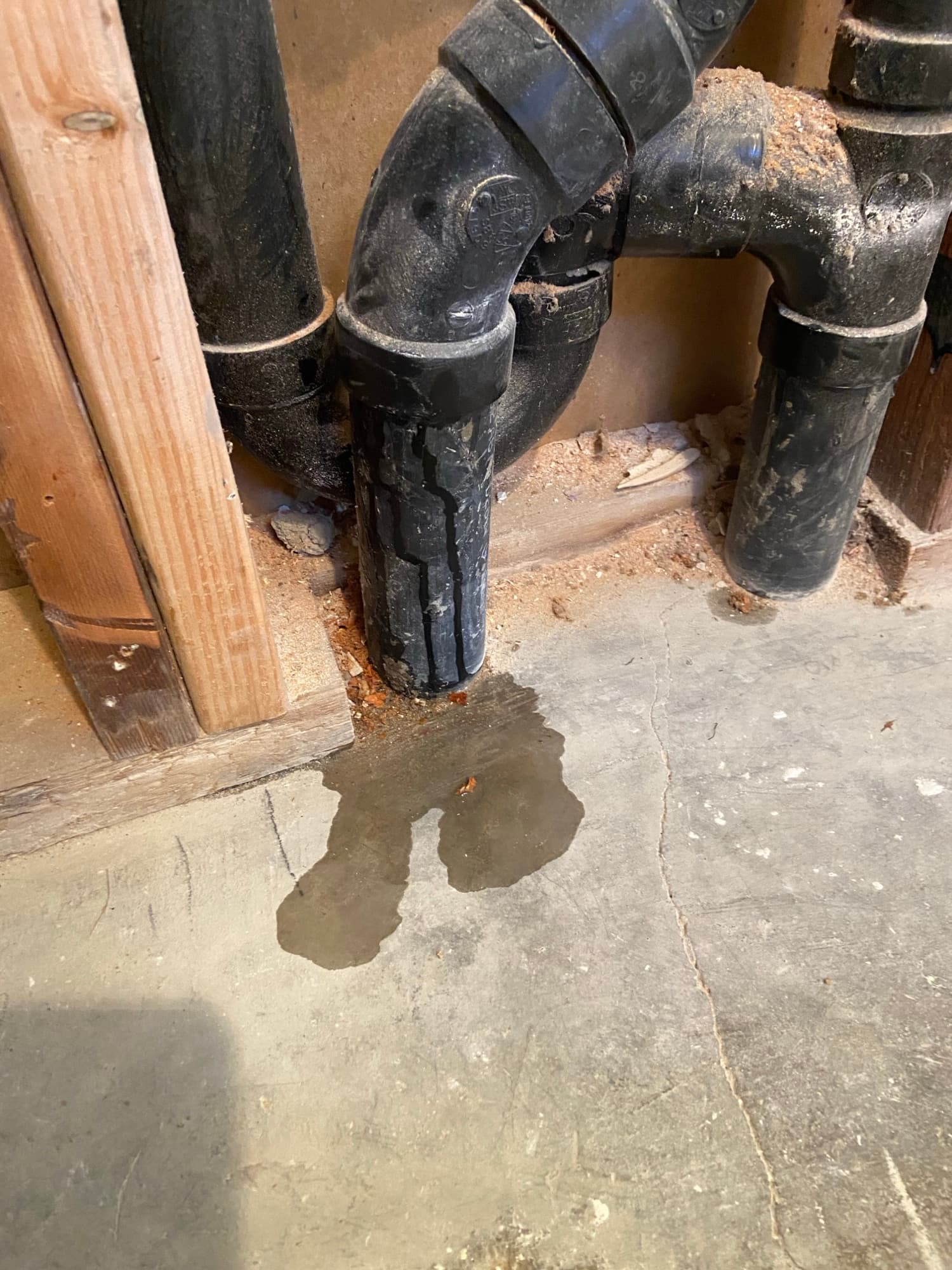 ABS pipe fitting and wet cement patch marking a completed slab plumbing repair, Orange County, CA