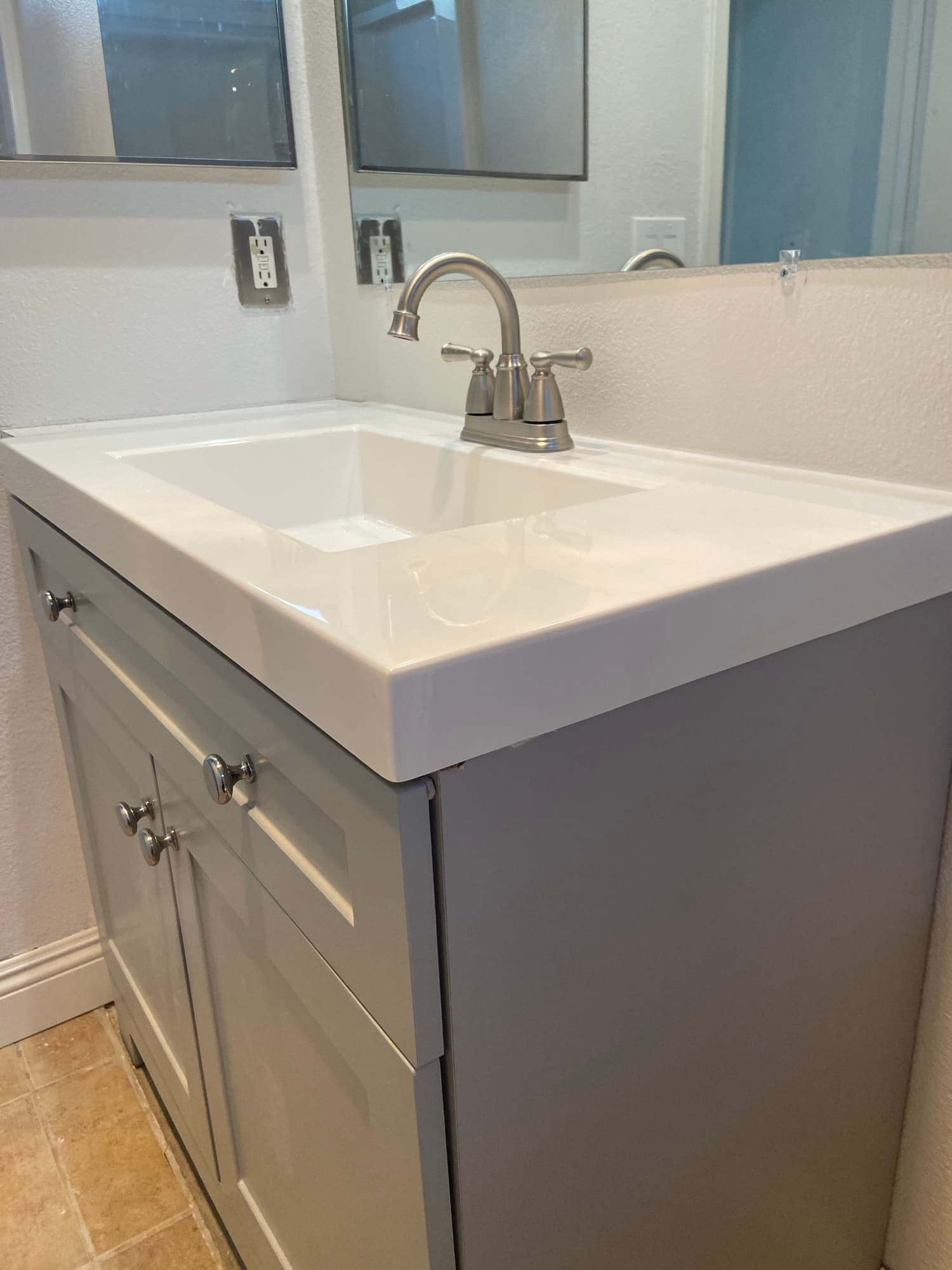 New bathroom vanity with a brushed nickel faucet installed above a single sink, Orange County, CA